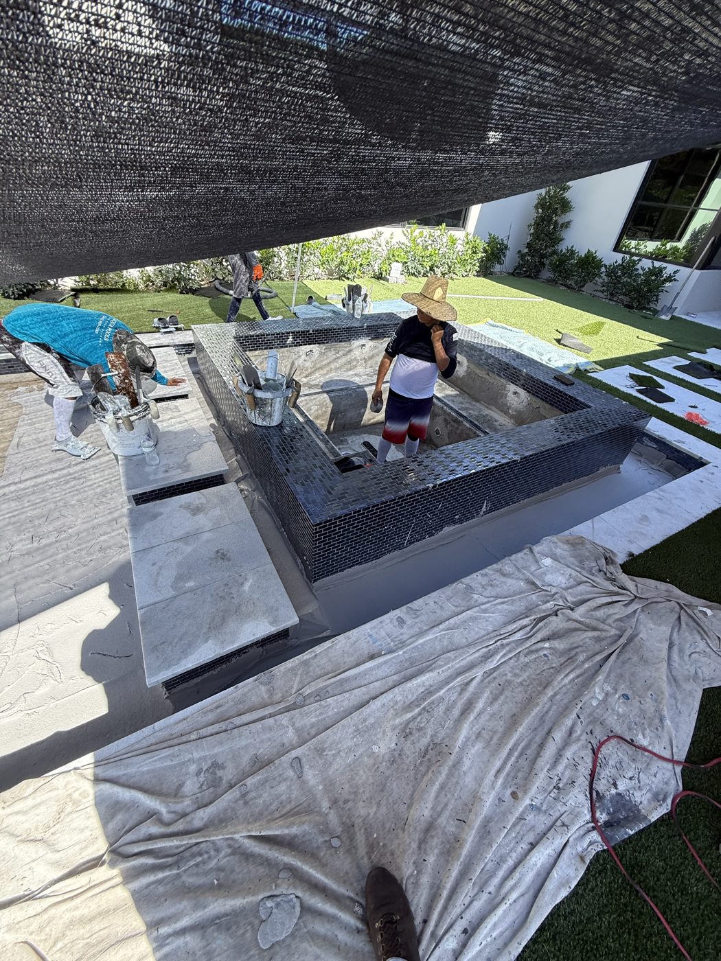 Crew applying the Florida Stucco finish under a shade cloth