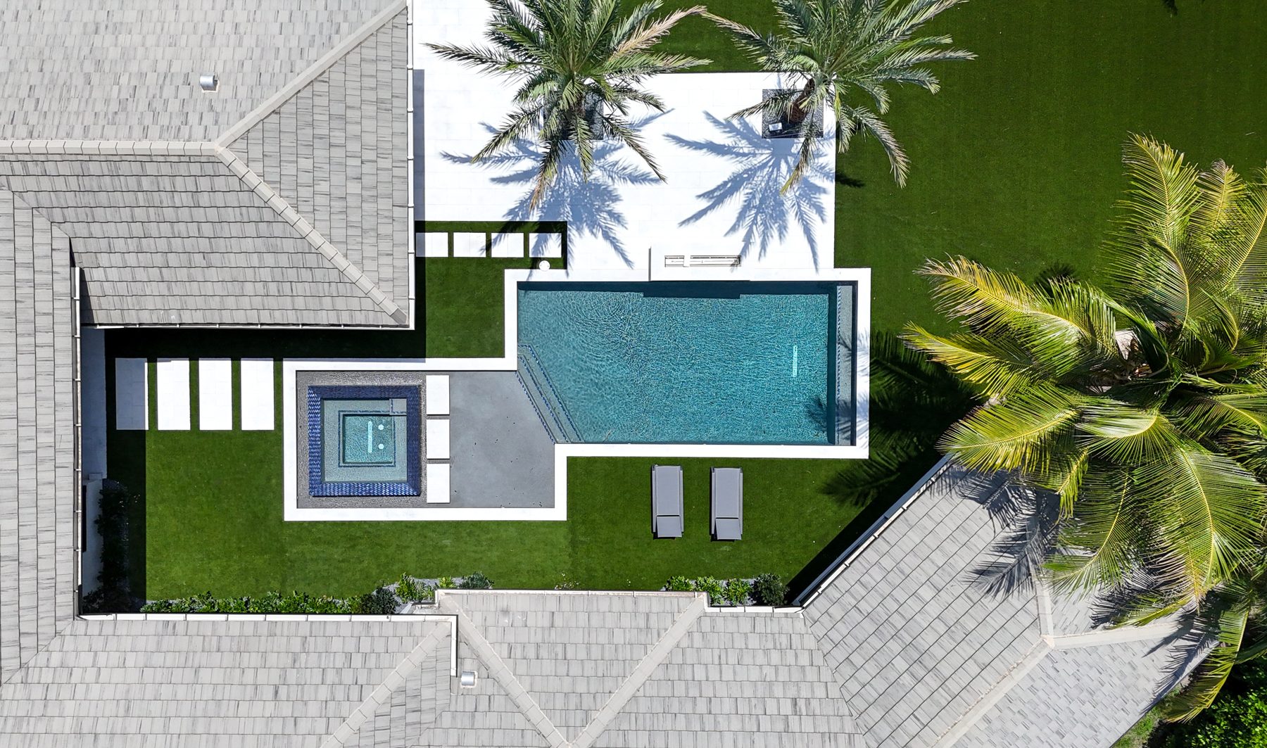 Top-down drone photo of the finished pool and spa matching the render