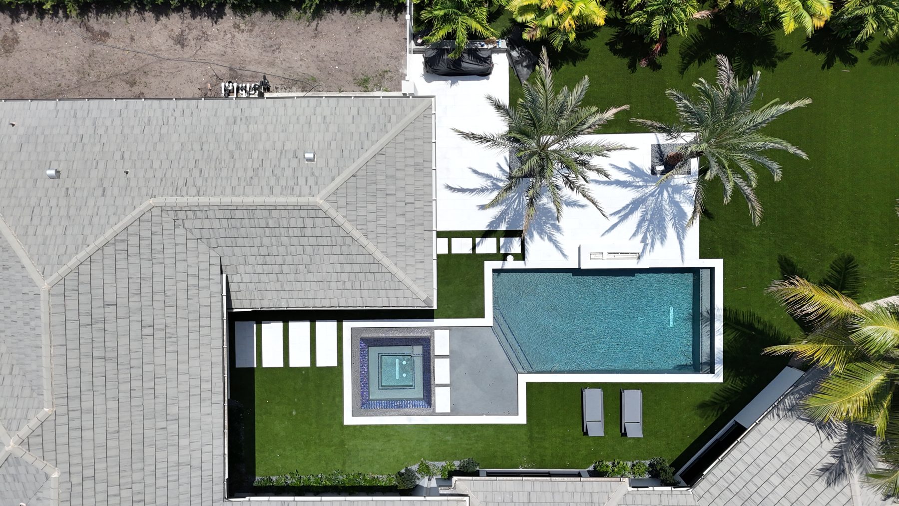 Drone view of the finished pool, spa and marble deck set into artificial turf