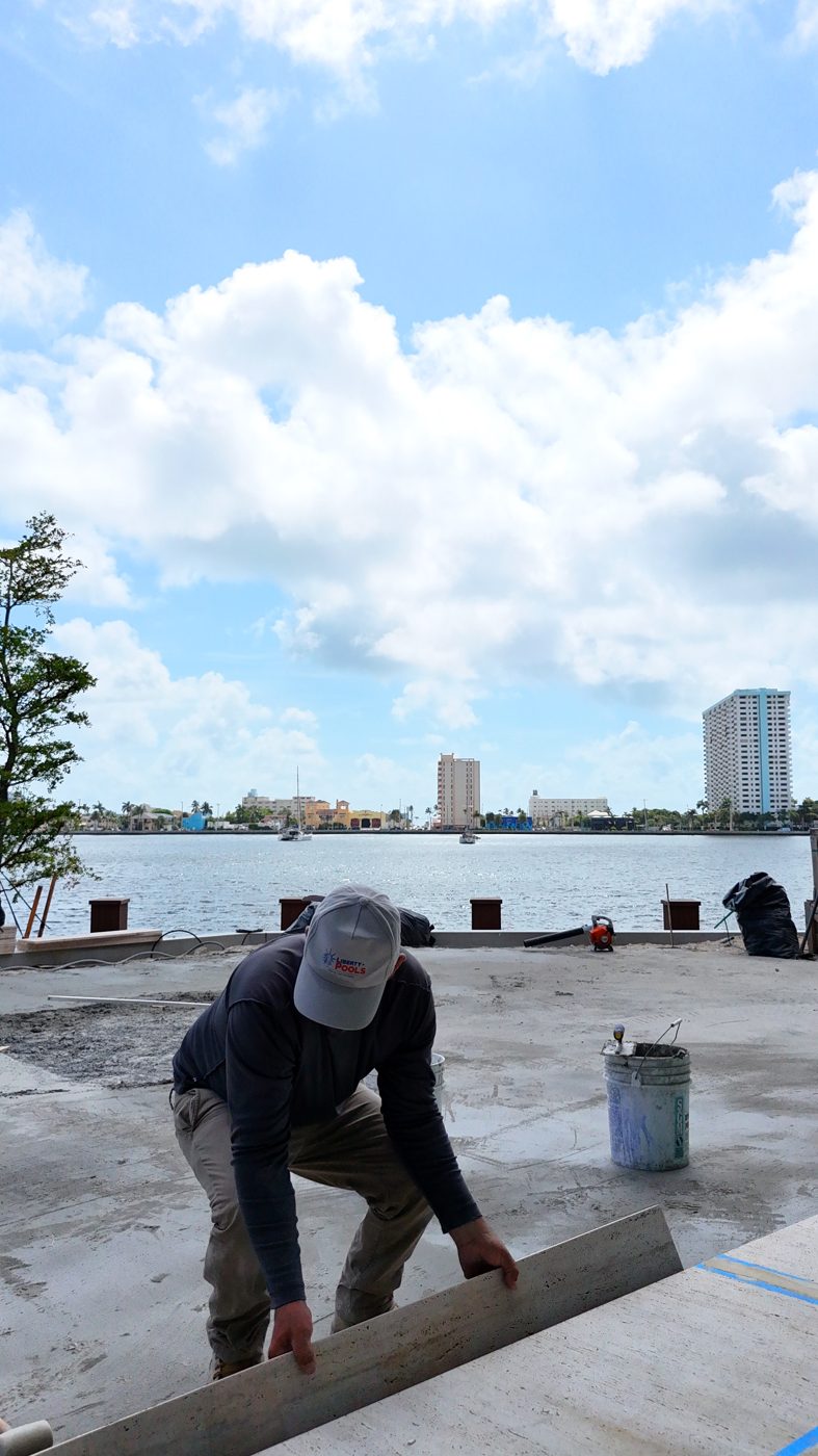 Close view of emerald porcelain tile being set on the pool floor