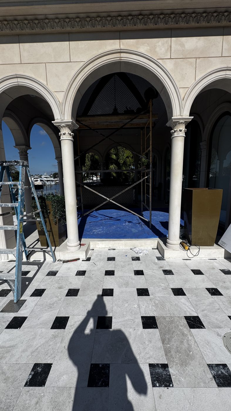 New marble deck with black inlays laid out in front of the arches
