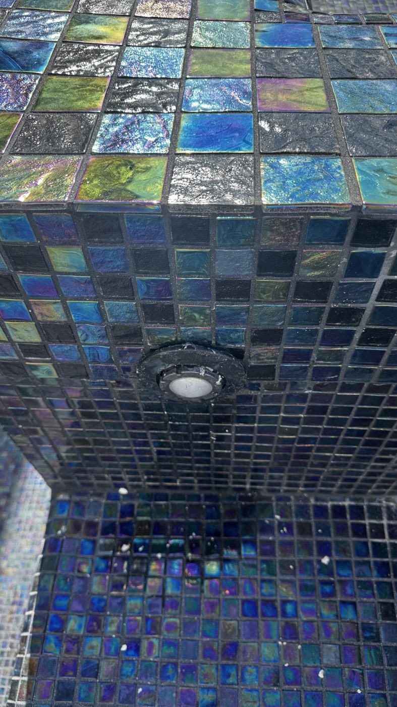 Close view of the iridescent glass mosaic around a nicheless LED light
