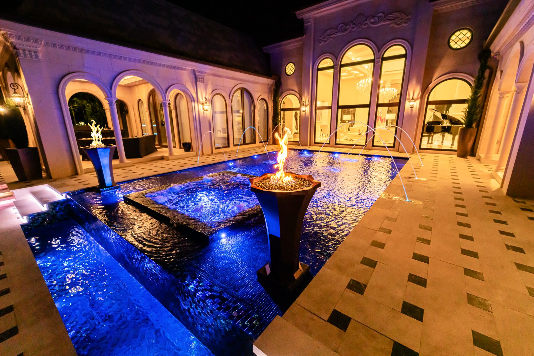 Laminar jets arcing into the pool with the lit house behind