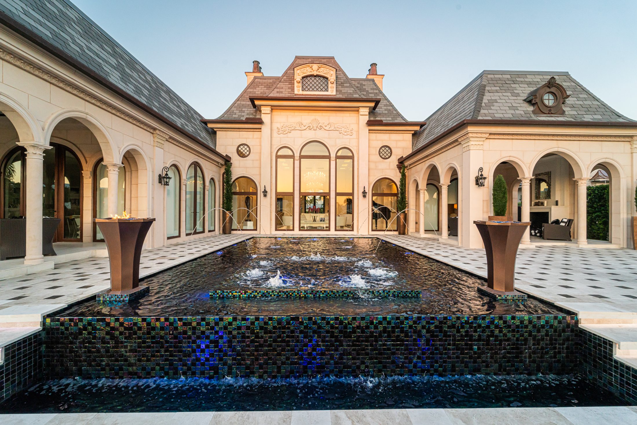 Evening view of the Markovitz pool after the remodel: new glass tile, laminar jets and the marble deck in front of the estate